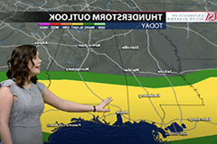Female student giving weather announcement in front of green screen.