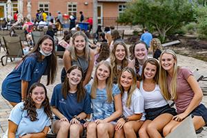 Students smiling in a group at the outdoor deck of the campus rec center.