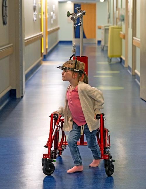 Abby Flowers navigates the halls of USA Health Children’s & Women’s Hospital with the help of a halo gravity traction-equipped custom walker. 